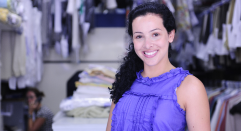 Smiling woman in front of clothing